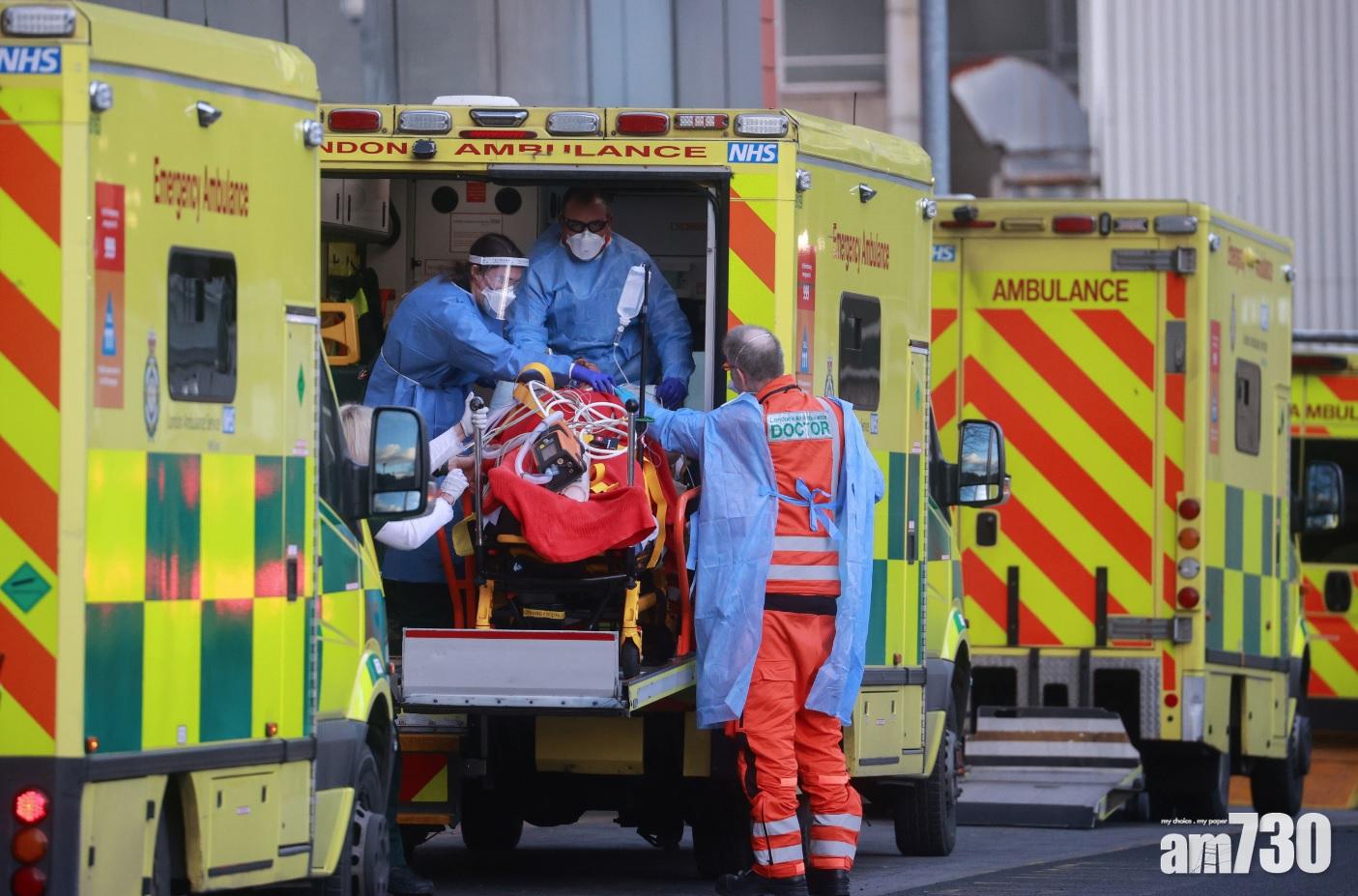 疫情下,倫敦醫護穿保護衣移送病人。(路透社)