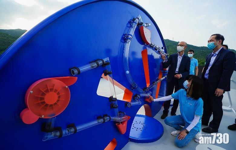 中華電力總裁蔣東強和環境局長黃錦星與學生一同接駁「發電大挑戰」遊戲的磁力管道。