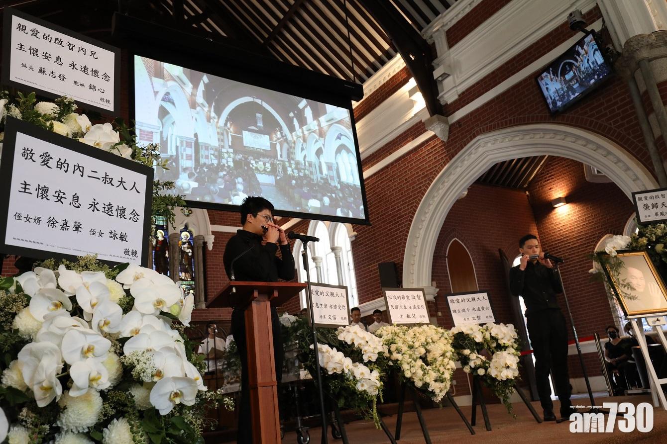 大仔文哲同二仔文信在安息禮上吹奏口琴送別父親。