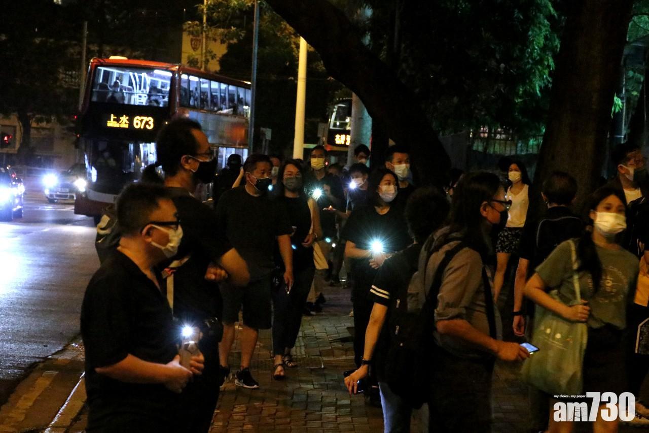 部分市民在維園外亮著手機電筒燈。(林俊源攝)