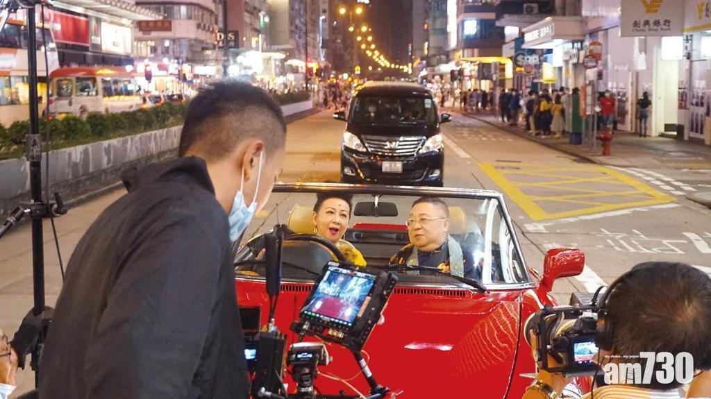 李居明和家燕姐在彌敦道拍攝。