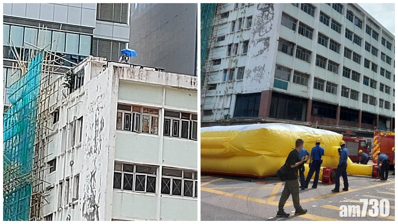 疑因賠償問題,觀塘裕民坊男子持傘危坐天台。(香港突發事故報料區@FB)