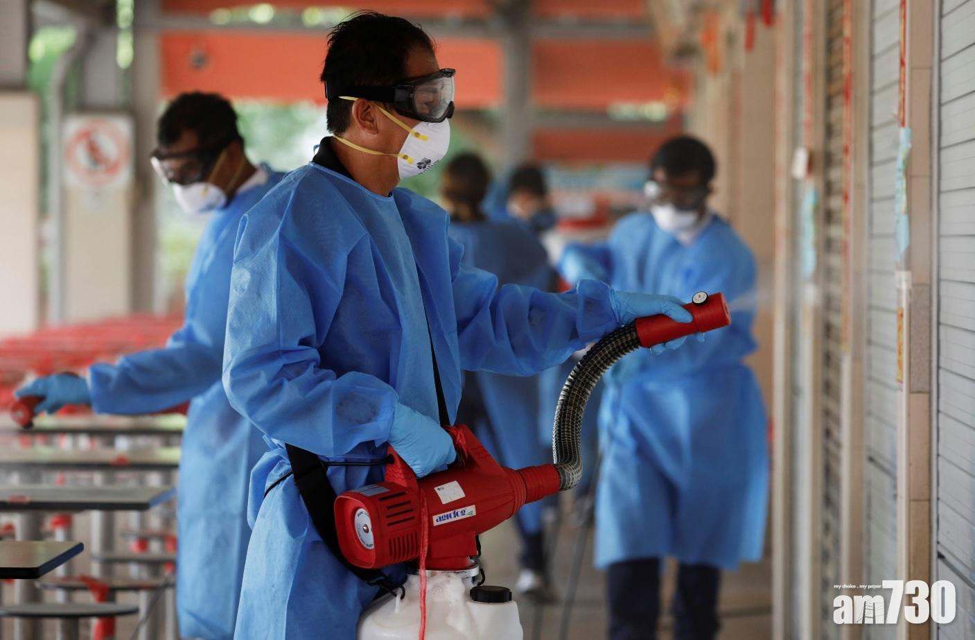 衛生人員日前到有檔販確診的熟食中心消毒。(路透社)