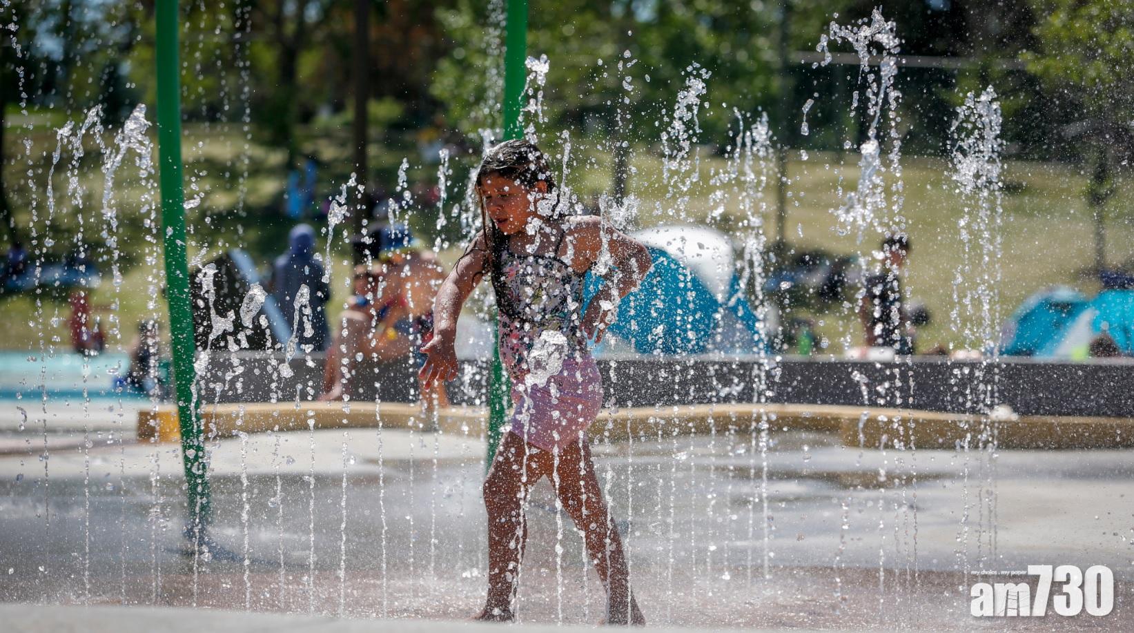 加拿大艾伯塔省一名女童玩水消暑。(美聯社)