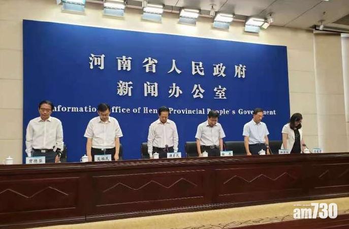 河南政府官員今午公布災情前,為遇難者默哀。(互聯網)