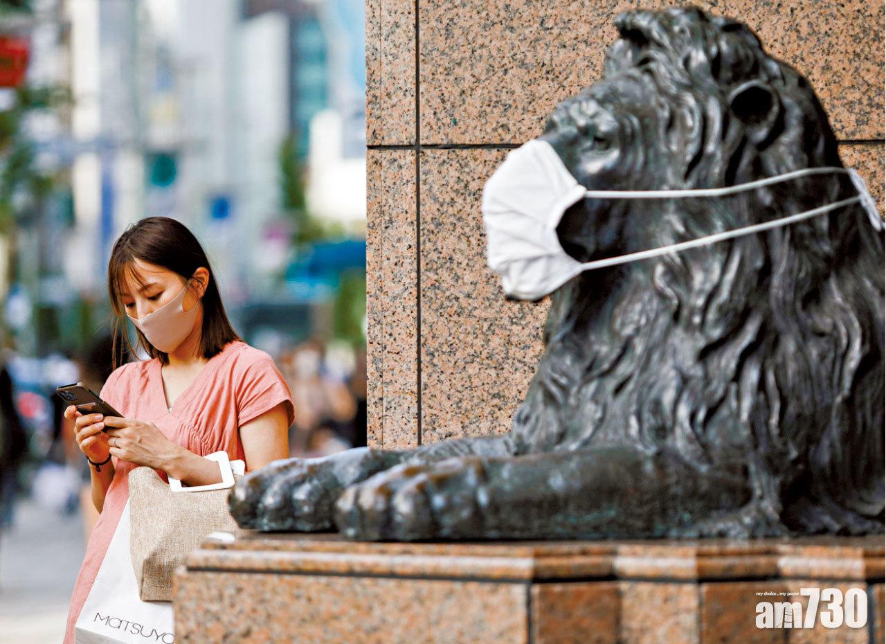 東京銀座民眾及獅子雕塑都戴上口罩。(路透社)
