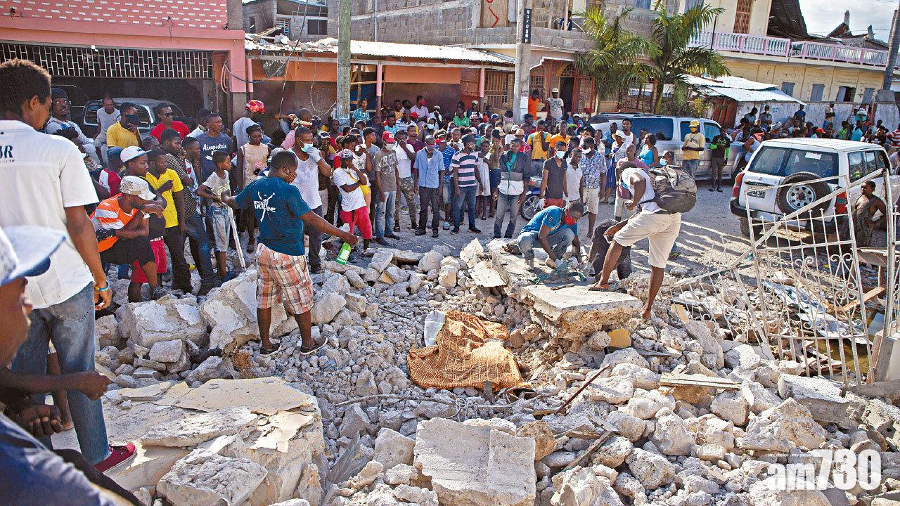 萊凱民眾在瓦礫中掘出一具遺體,用布覆蓋。(路透社、美聯社)