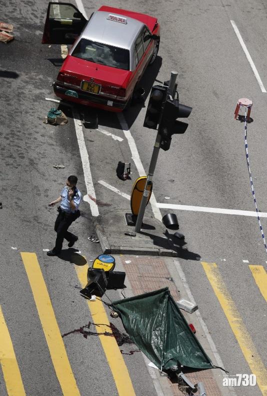 遺體以帳篷覆蓋在安全島,地下留有血跡。(林俊源攝)