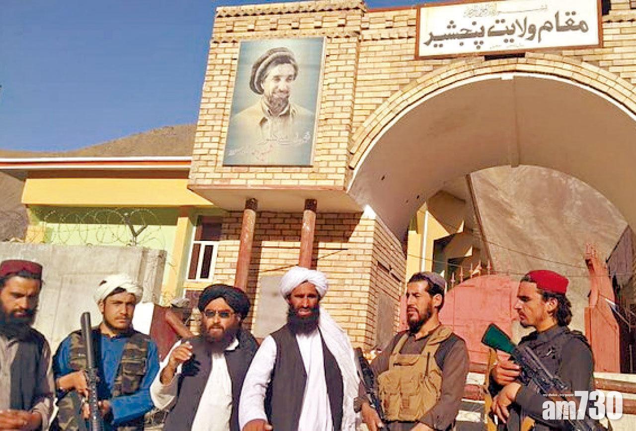 塔利班分子昨佔據潘傑希爾省,在省政府辦公室前合照。(路透社)