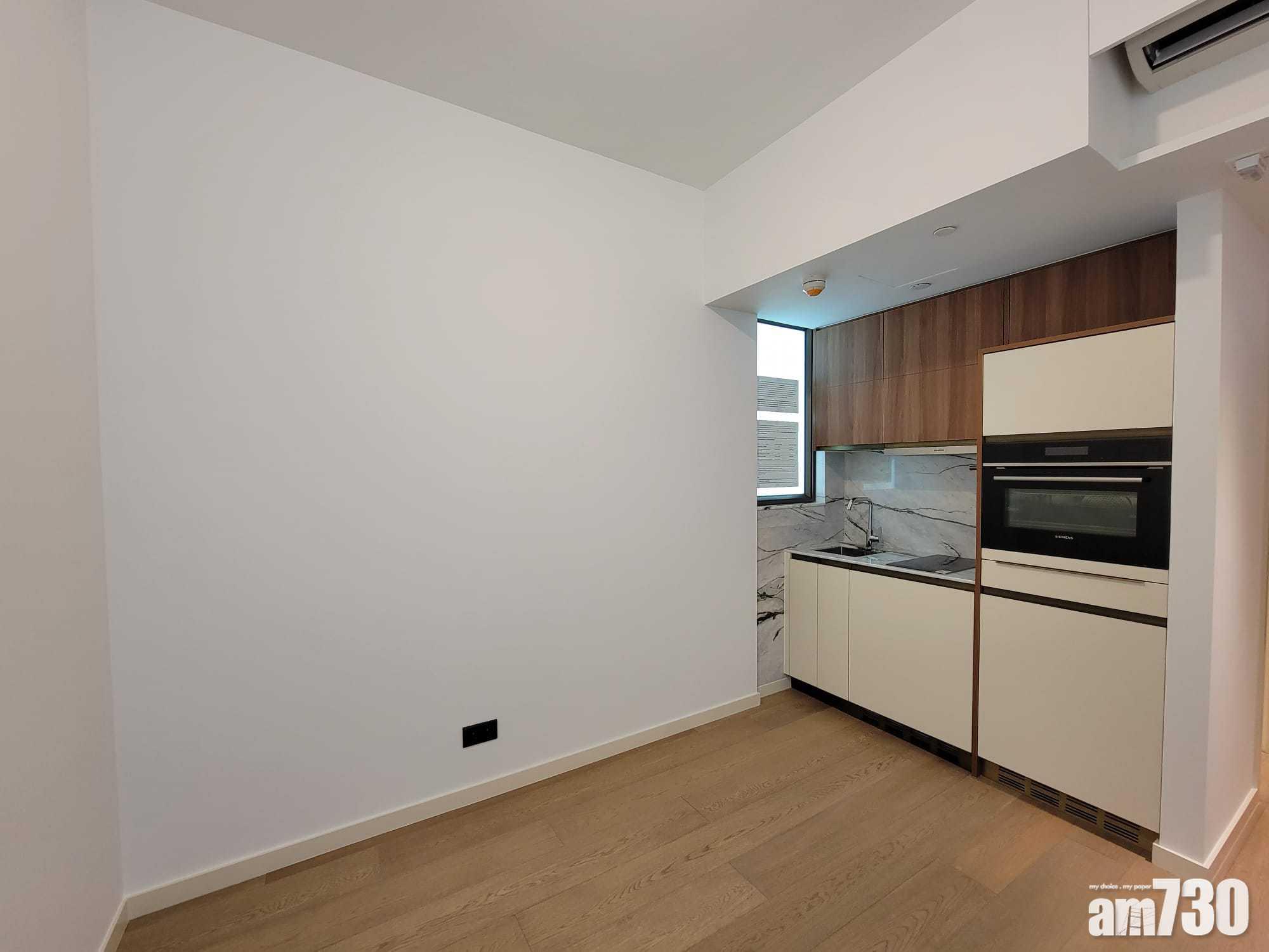 開放式廚房旁邊設有通風窗口,配備名牌家電,如洗衣機、雪櫃、電磁爐等。(莊振邦攝)