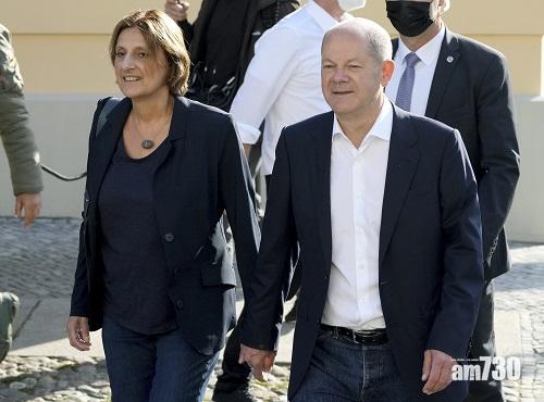 肖爾茨領導的社民黨領先1個百分點,選情緊湊,他與妻子一起抵達票站。(美聯社)