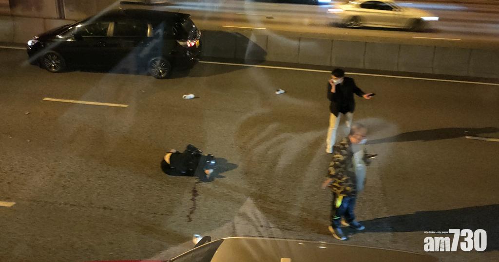 有兩名男子站在傷者前擋車,避免傷者被其他車輛輾過。(香港突發事故報料區FB)