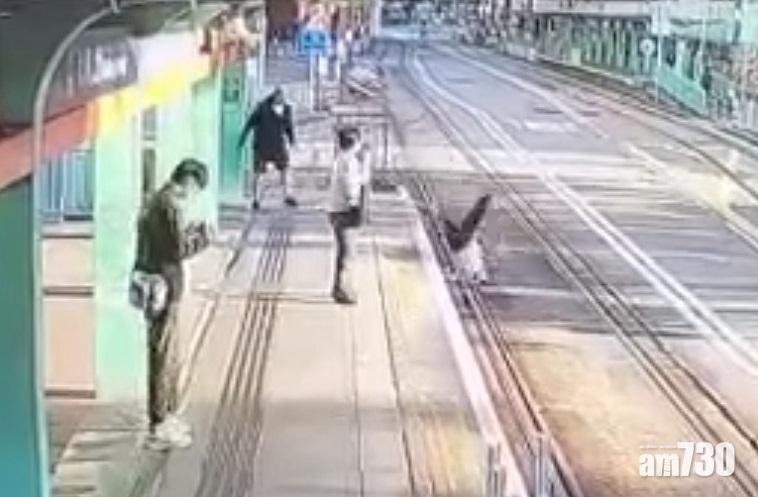 女子被推後翻滾一圈直墮輕鐵路軌。(網上片段截圖)