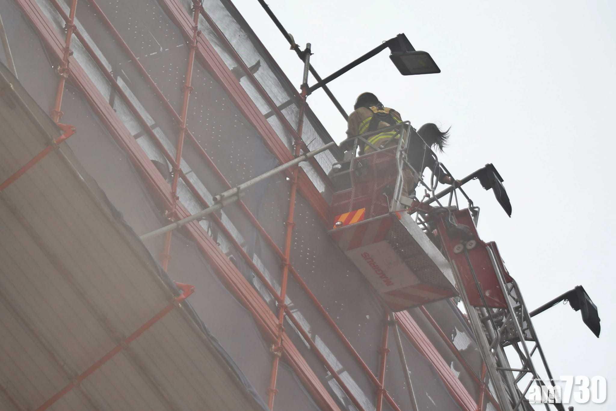 消防架起雲梯,逐一接走被困的市民。(莊振邦攝)