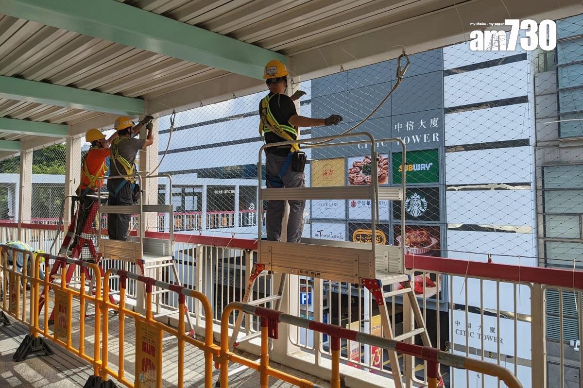橫跨金鐘夏慤道、連接政府總部的行人天橋,有工人正安裝較輕型及耐用的圍網。(羅庸軒攝)