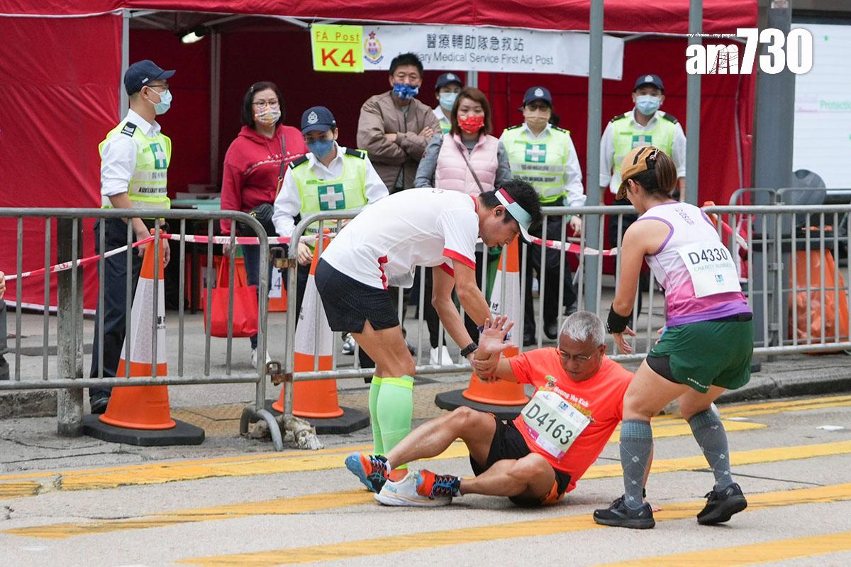 渣打馬拉松2月12日舉行,有不慎跌倒的跑手由其他跑手扶起。(李睿哲攝)