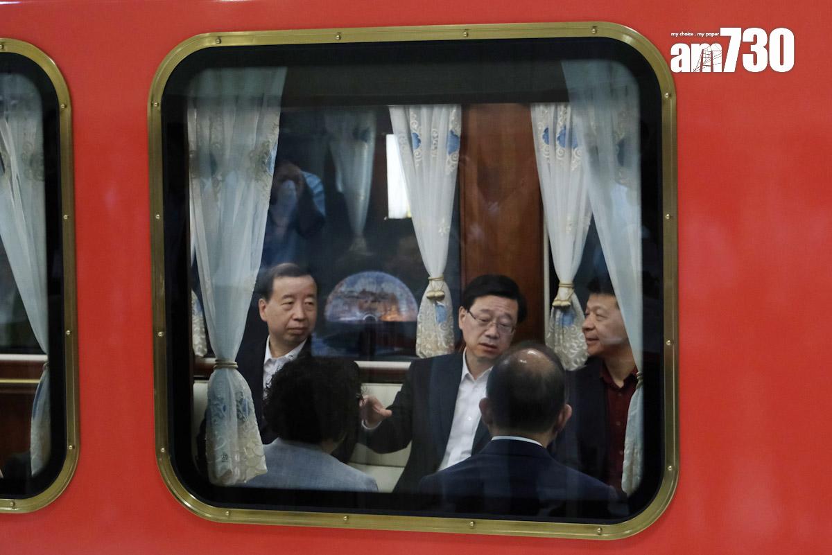 李家超(中)由肖亞非(左)及郭平陪同乘搭小火車。(羅庸軒攝)