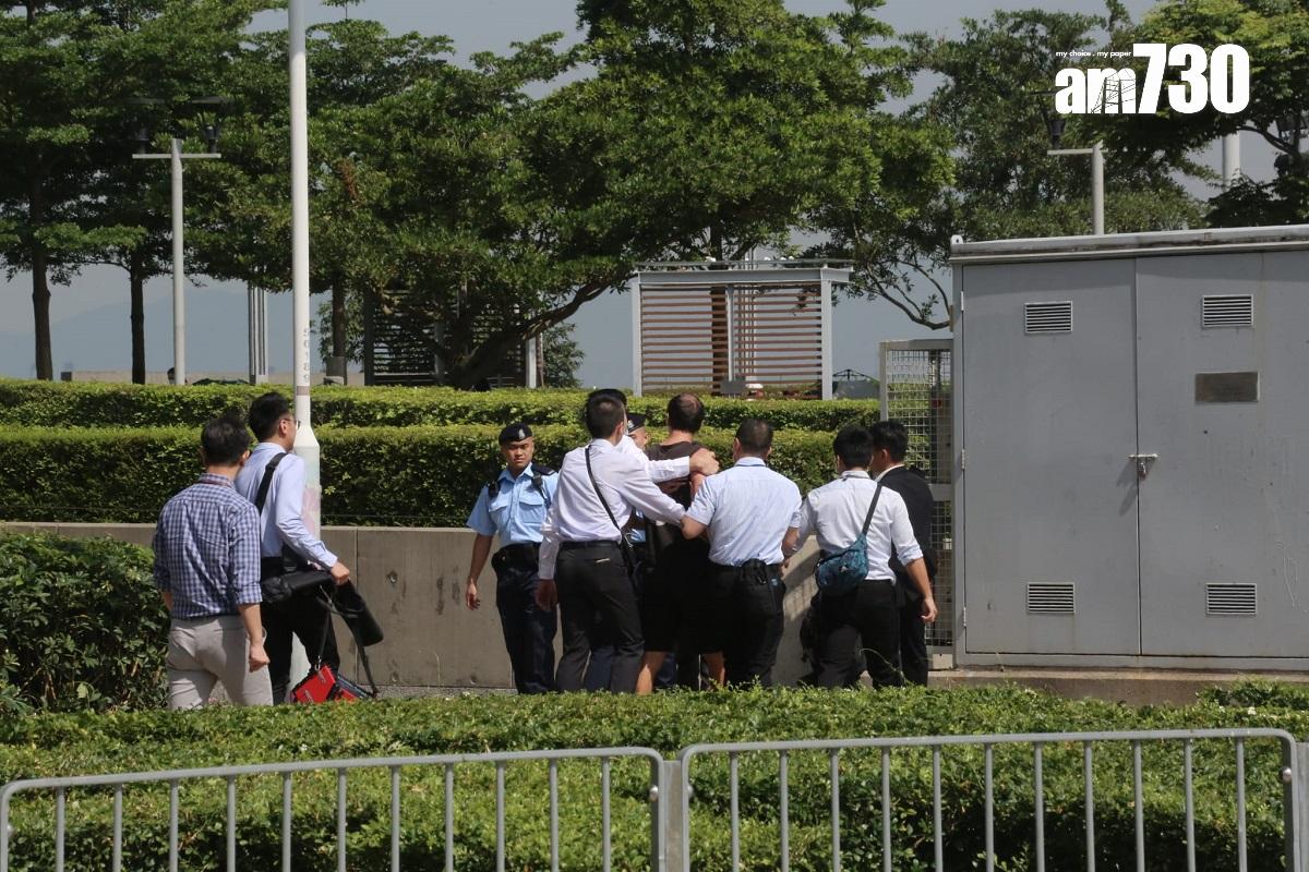 一名外籍男子(左五)欲在立法會外展示易拉架表達訴求,被警員阻止及帶離。(董立華攝)