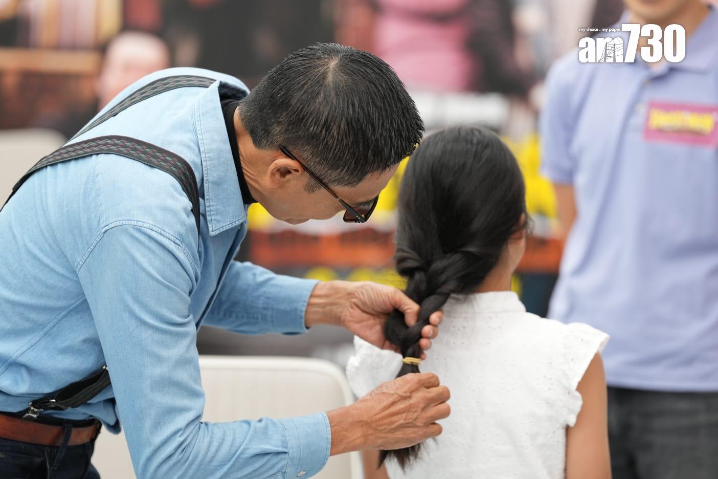 發哥為三位小朋友「剪髮」。 (陳奕釗攝)