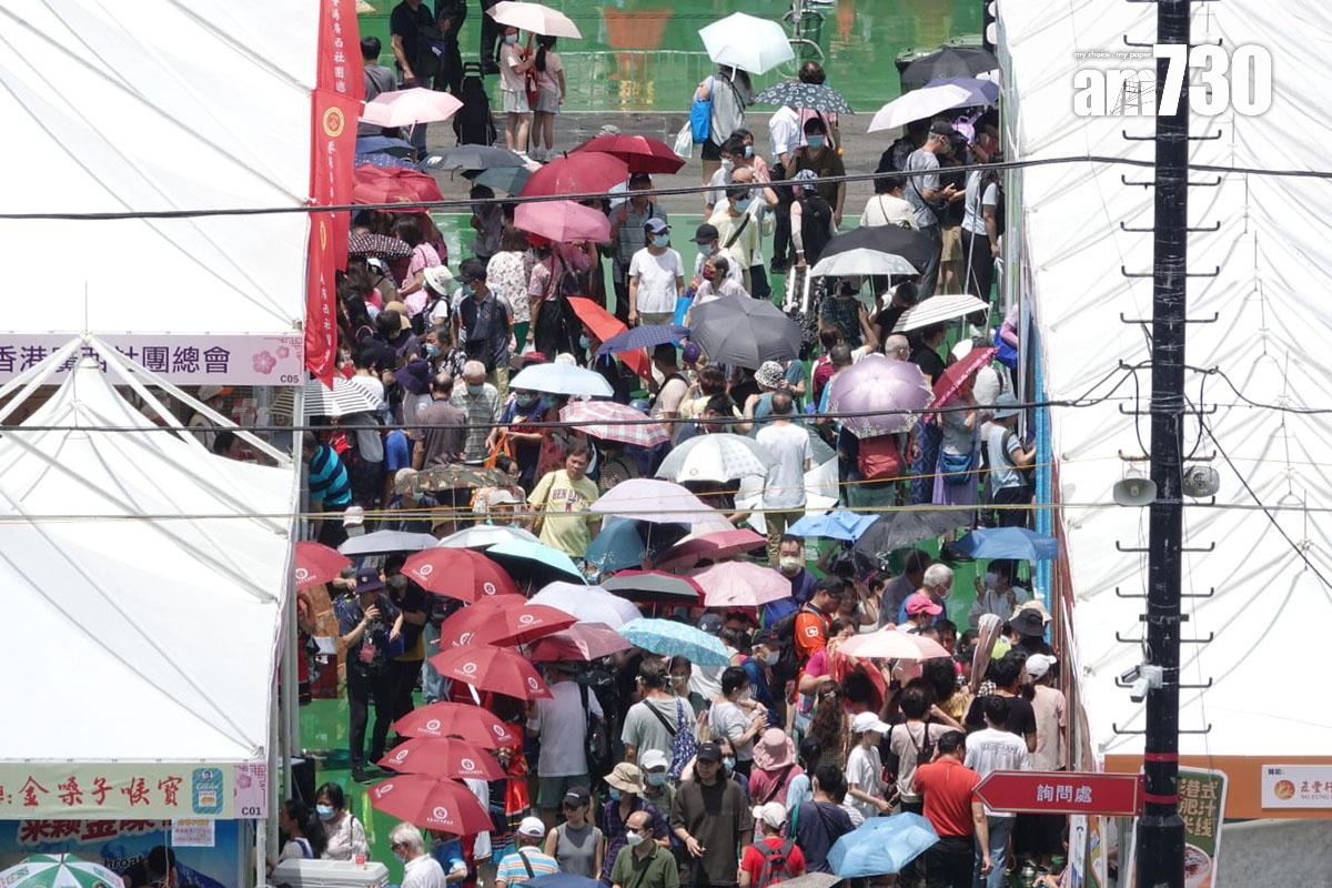 今日是六四事件34周年,維多利亞公園正舉行「家鄉市集嘉年華」,不少市民烈日當空下要撐傘遮蔭。(陳奕釗攝)