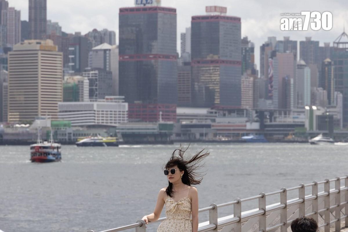 熱帶風暴泰利襲港的周日,下午間中烏雲蓋頂,不少遊客繼續到尖沙咀欣賞維港景色。(蘇文傑攝)