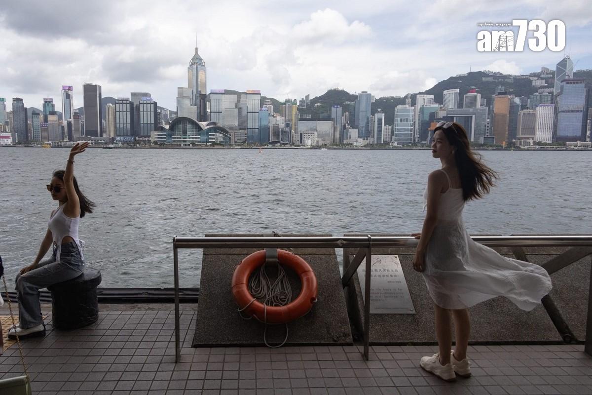 熱帶風暴泰利襲港的周日,下午間中烏雲蓋頂,不少遊客繼續到尖沙咀欣賞維港景色。(蘇文傑攝)