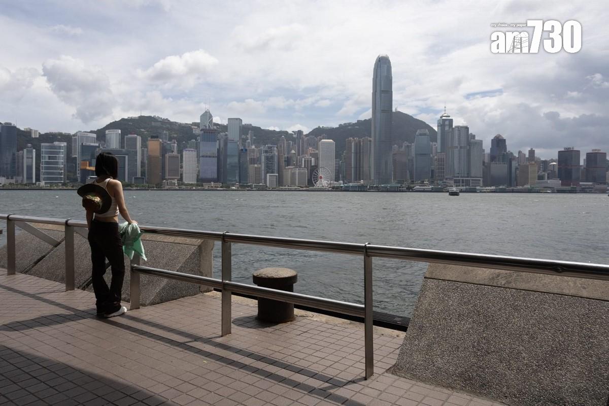 熱帶風暴泰利襲港的周日,下午間中烏雲蓋頂,不少遊客繼續到尖沙咀欣賞維港景色。(蘇文傑攝)