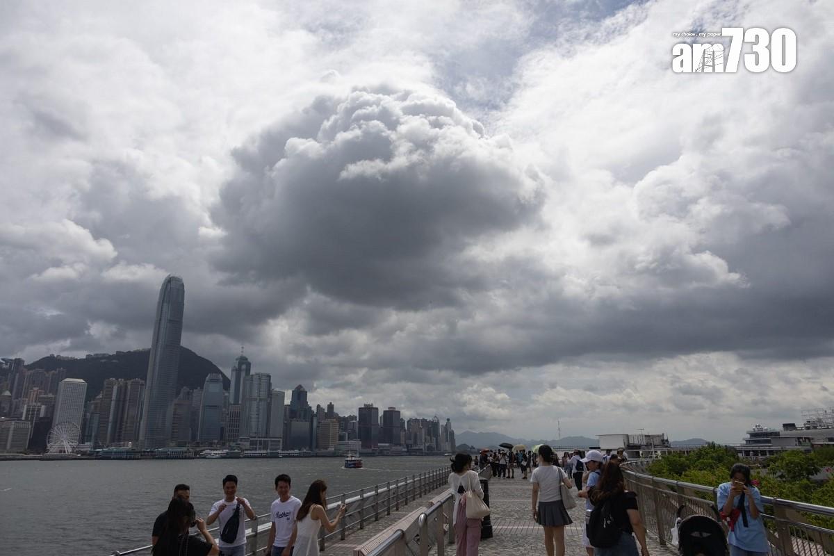 熱帶風暴泰利襲港的周日,下午間中烏雲蓋頂,不少遊客繼續到尖沙咀欣賞維港景色。(蘇文傑攝)