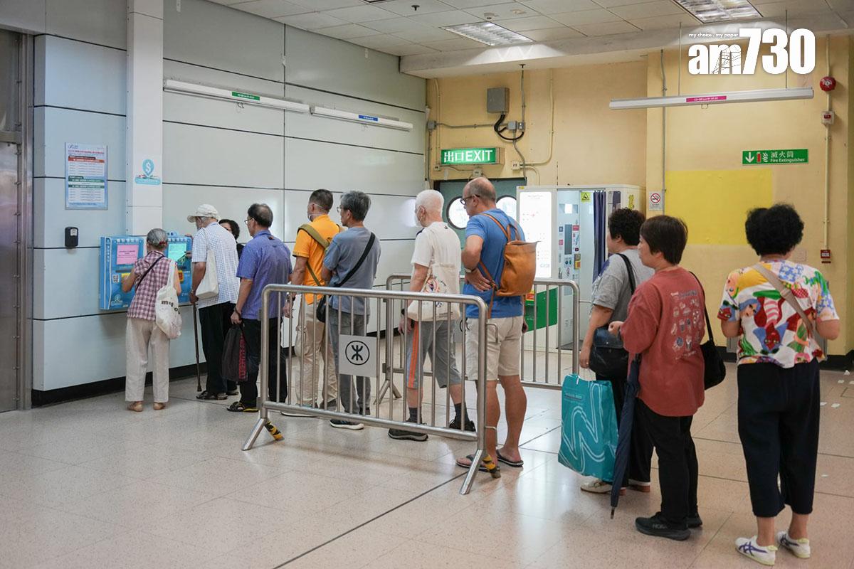 市民在第二期消費券發放首日,到港鐵站拍卡的補貼領取站領取。(李睿哲攝)