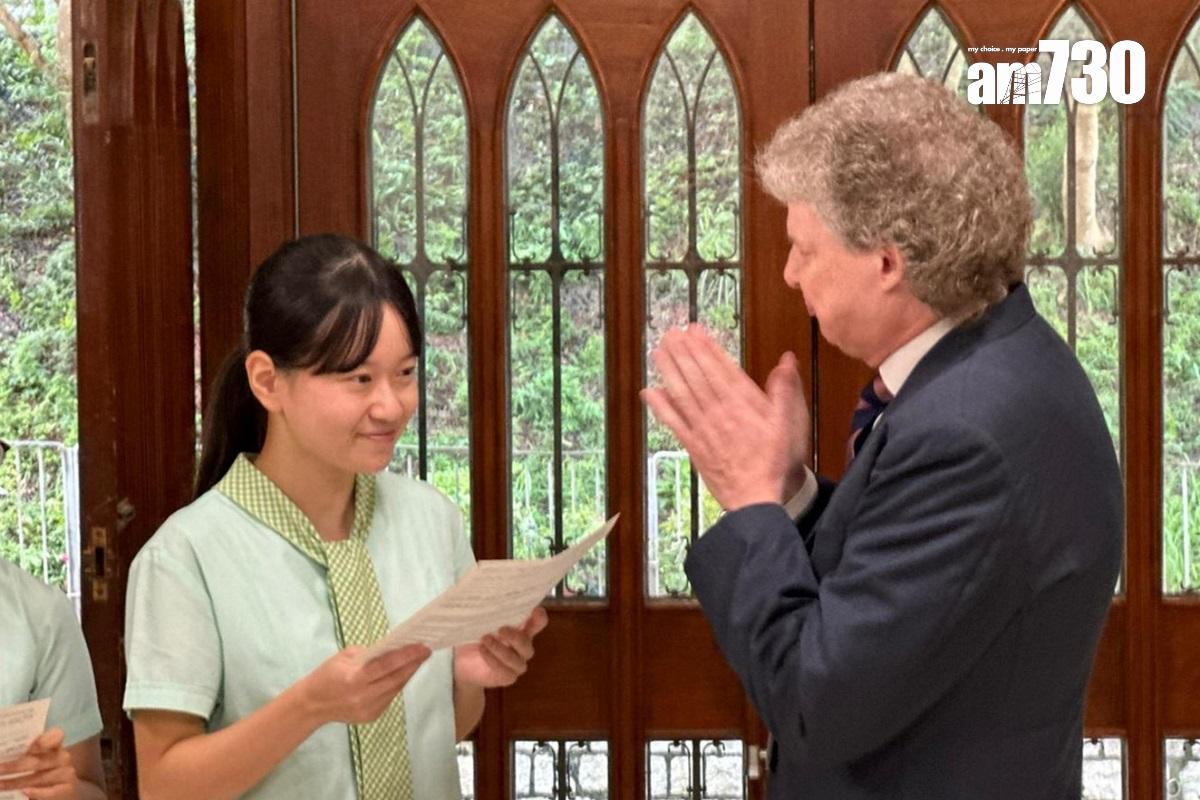 德望學校狀元鄭苡晴(左)早上接過成績單。(潘善怡攝)