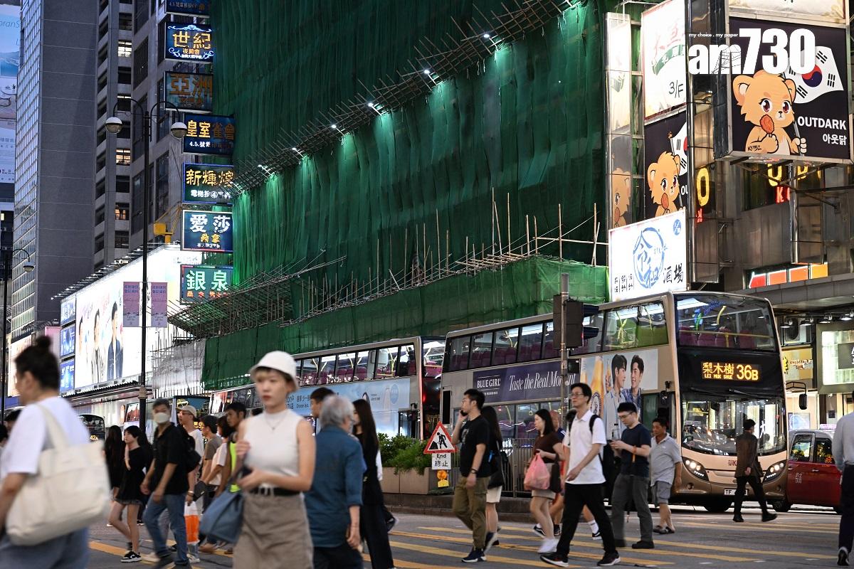 旺角新興大廈正維修外牆,外圍棚架有綠色尼龍網和斜棚防止物件墮下。(陳奕釗攝)