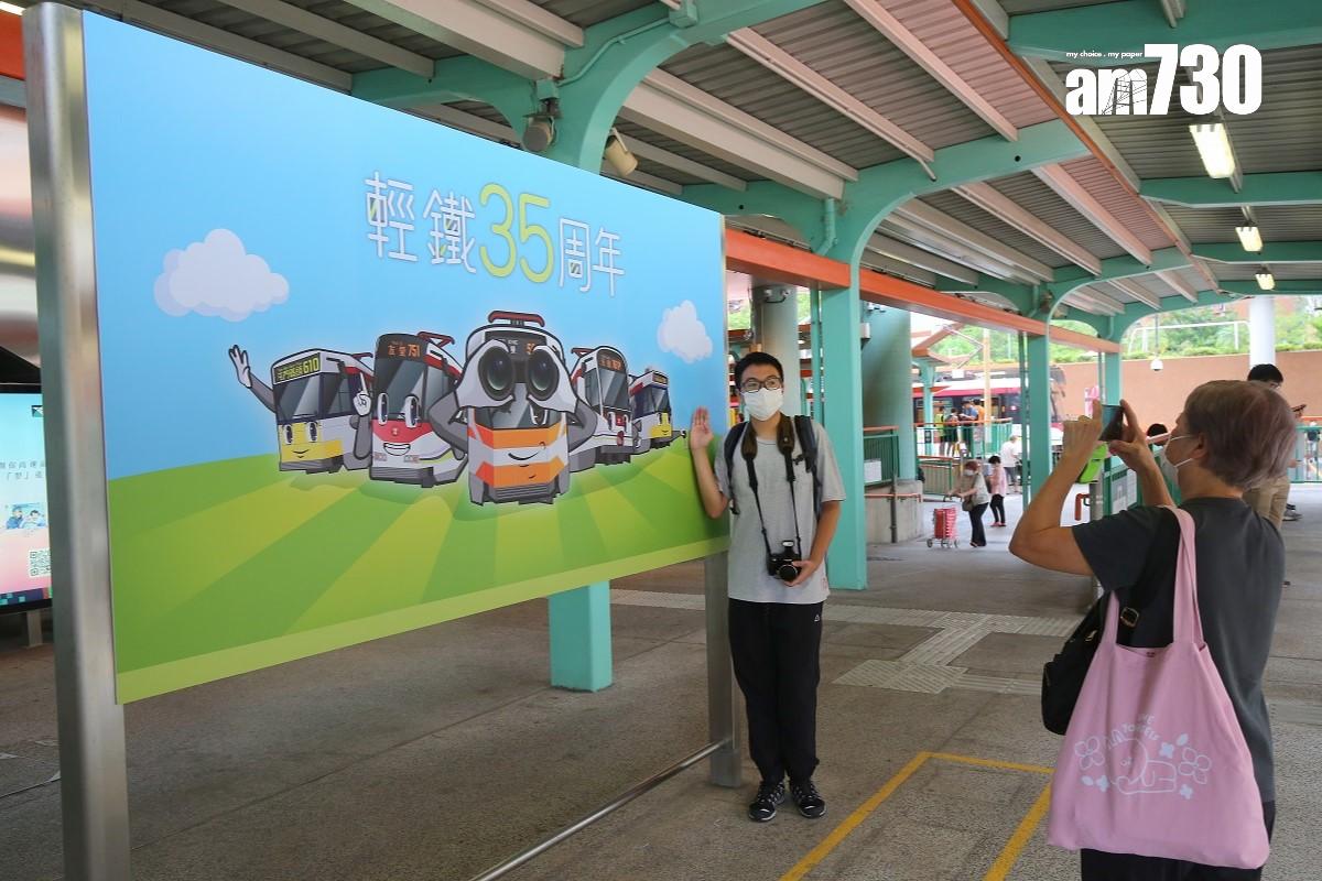 有市民到輕鐵兆康站參觀「35周年復刻主題輕鐵」,並與相關海報留影。(董立華攝)
