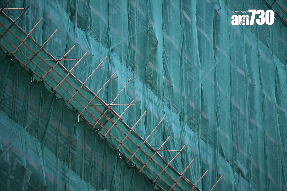 旺角新興大廈正維修外牆,外圍棚架有綠色尼龍網和斜棚防止物件墮下。(陳奕釗攝)