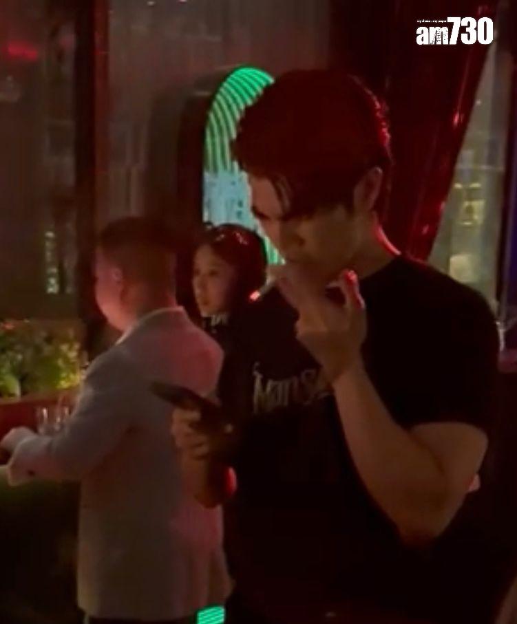 Mile一邊玩手機一邊吞雲吐霧。