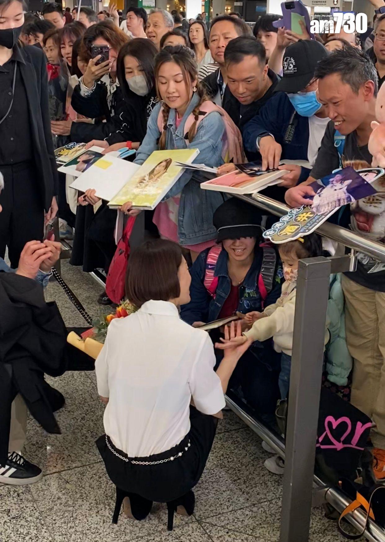 酒井法子踎低與小妹妹握手。