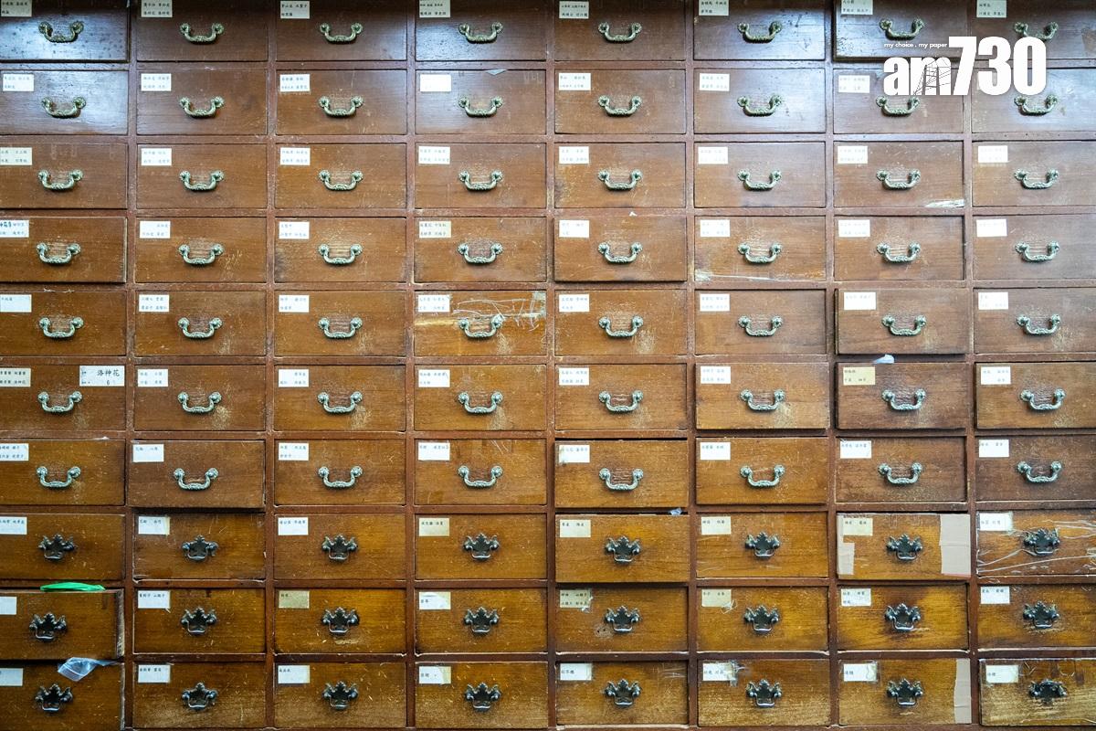 黃成堅最不捨得無法搬走的執藥百子櫃。(林靄怡攝)