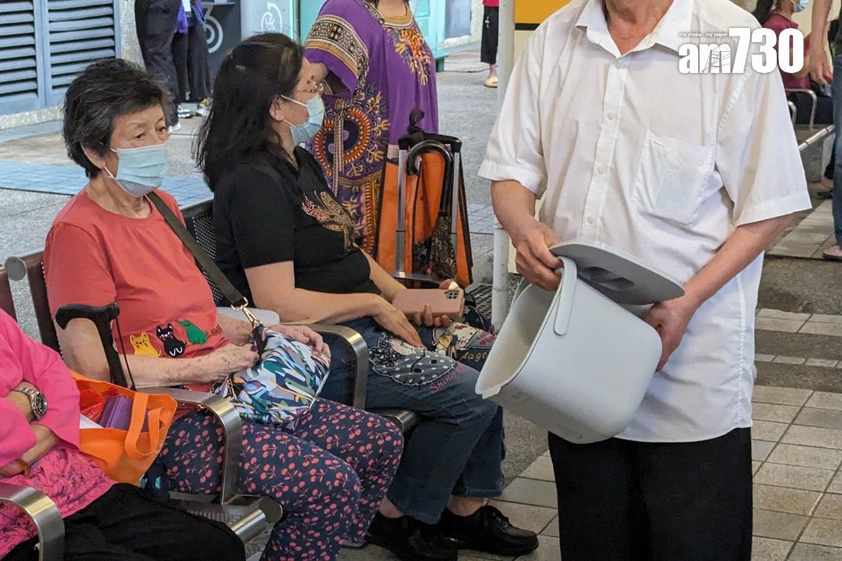 有居民獲發家居廚餘桶後即場拆解內裏結構。(羅庸軒攝)