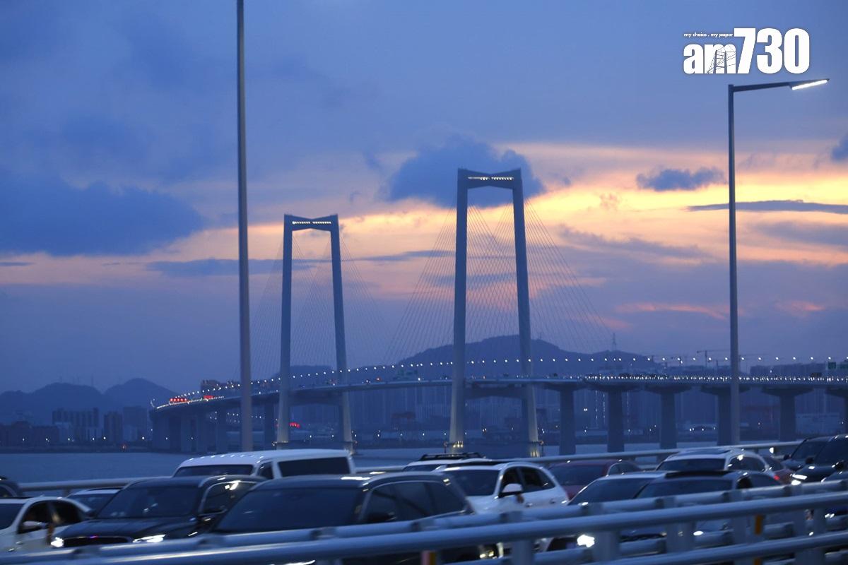 深中通道嚴重擠塞,乘客只好順道在車上欣賞落日晚霞。(林俊源攝)