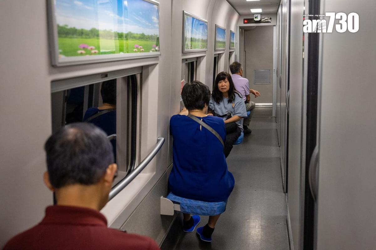 高鐵香港段動臥列車首航,晚上有不少人坐在走廊為電話充電。(陳奕釗攝)