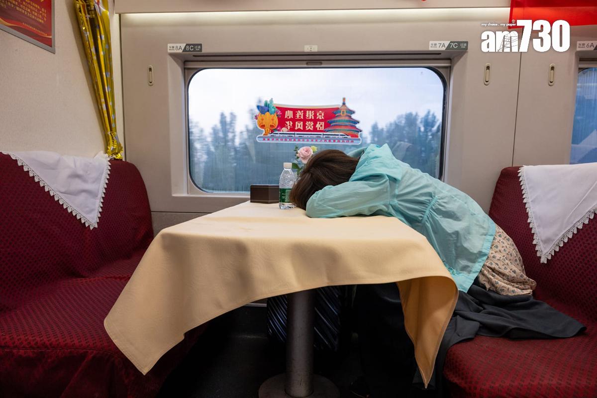 高鐵香港段動臥列車首航,有乘客在餐卡桌上小睡。(陳奕釗攝)