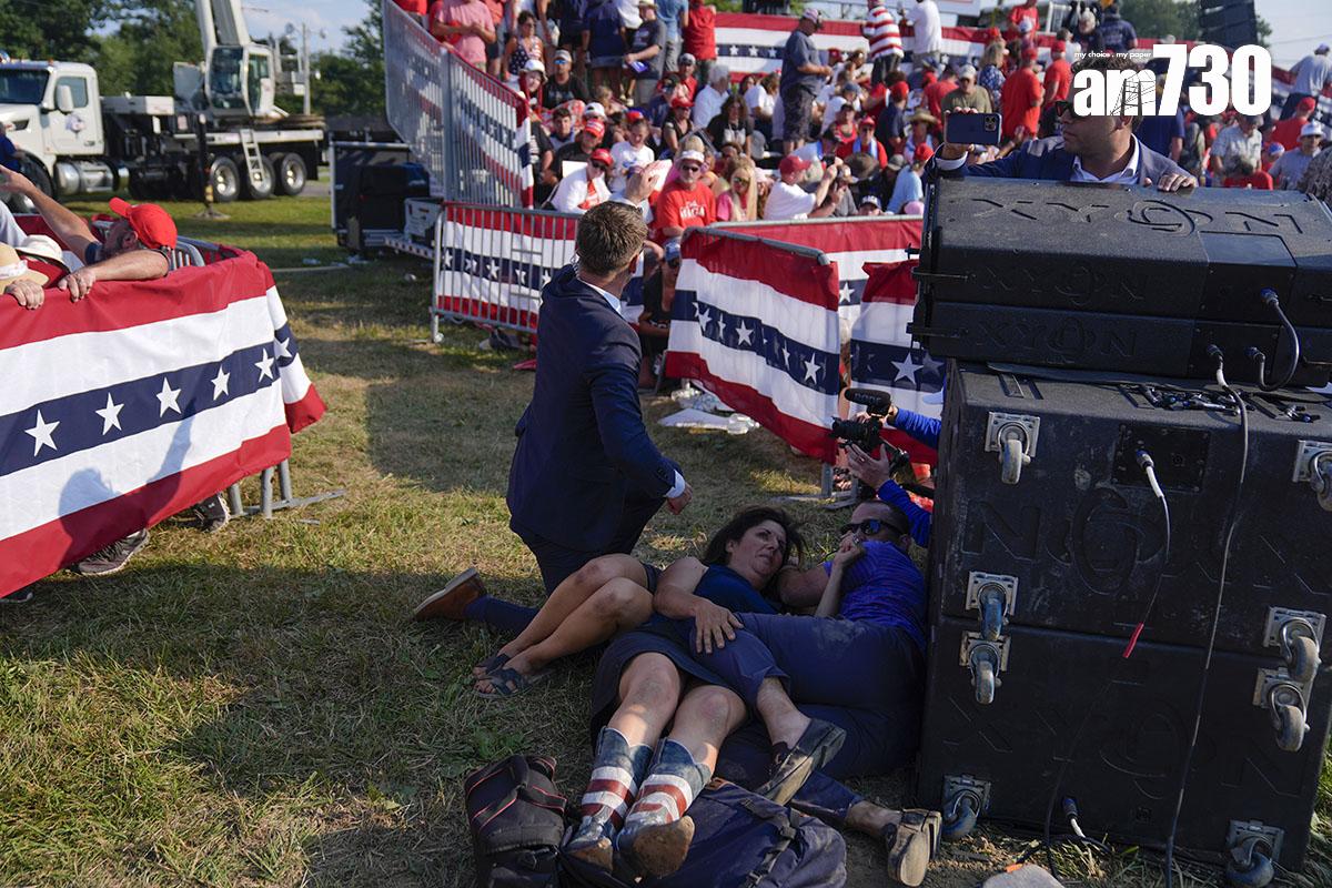 特朗普遇刺後由大批特工護送離開,現場一片混亂。(美聯社)
