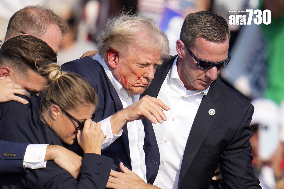 特朗普遇刺後由大批特工護送離開,可見他右耳流血。(美聯社)