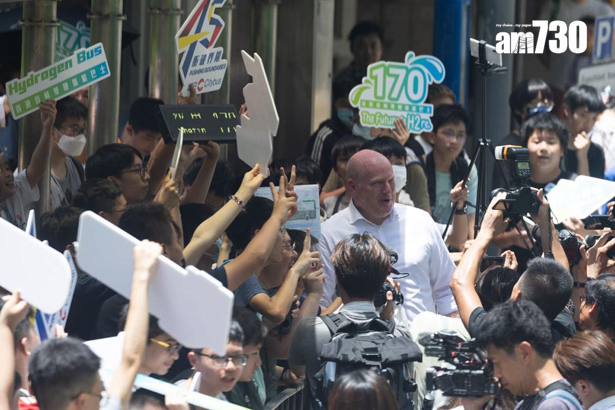 在巴士總站等候氫能巴士首航隧道線的巴士迷,與城巴董事總經理李卓豪合照。(蘇文傑攝)