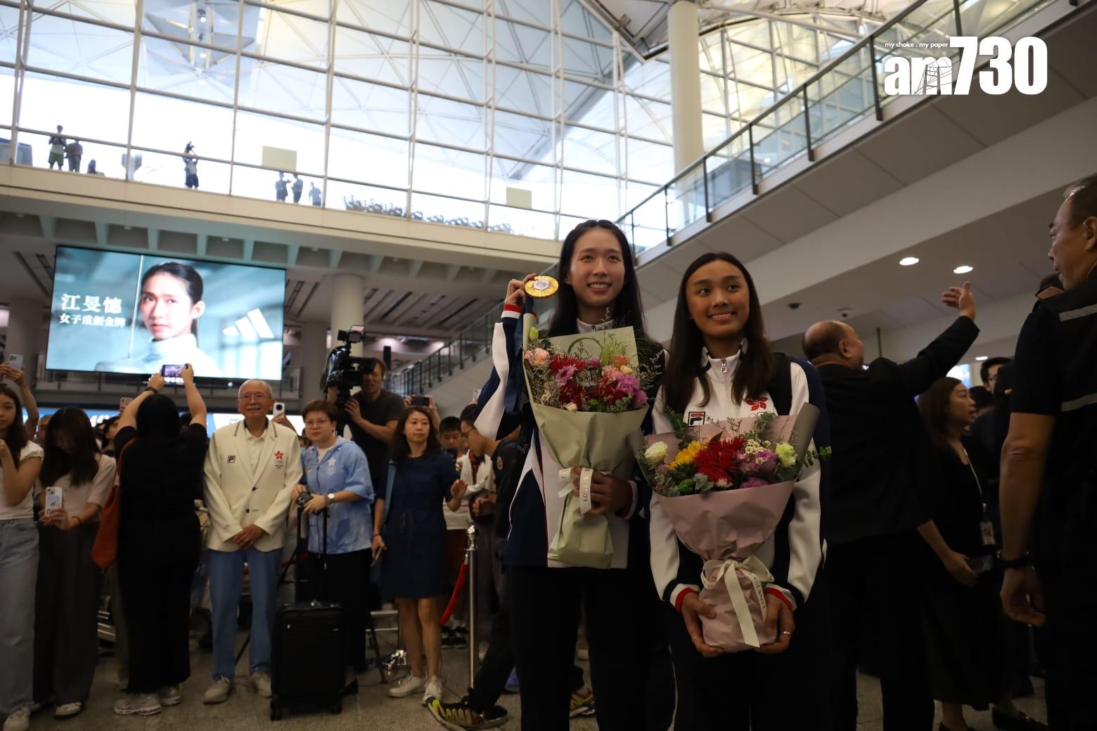 江旻憓早上約6時半步出入境大堂,她捧著花展現笑容。(鍾式明攝)