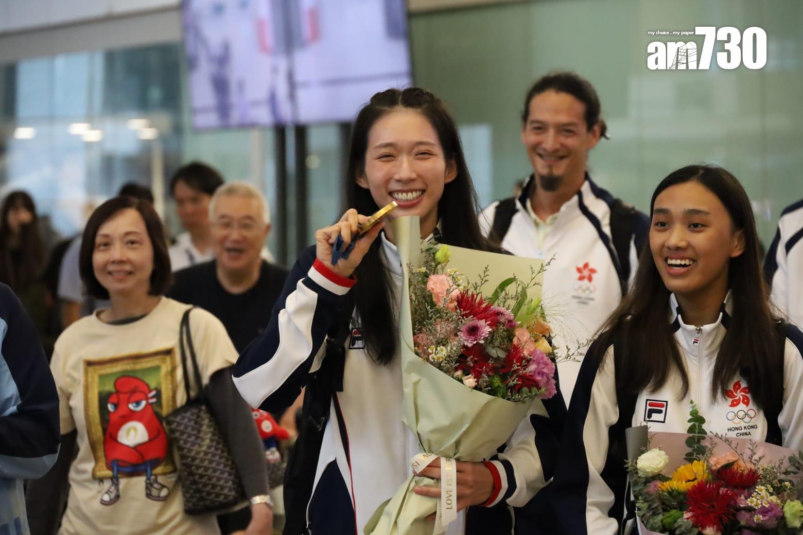 江旻憓早上約6時半步出入境大堂,她捧著花展現笑容。(鍾式明攝)