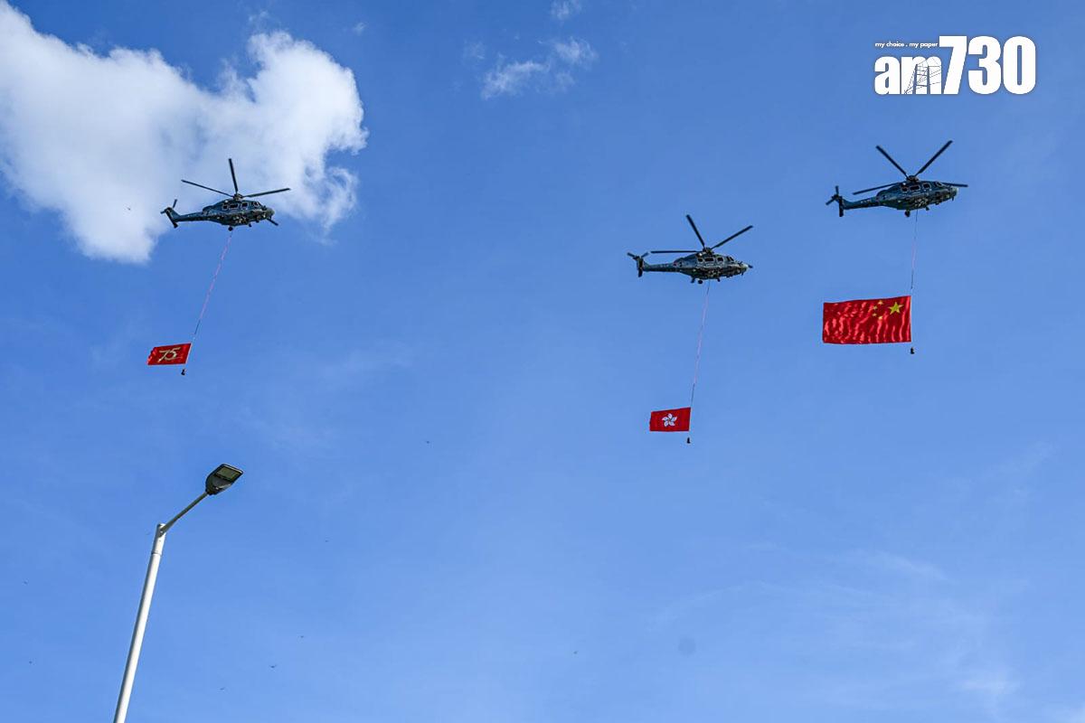 政府飛行服務隊派出分別懸掛國旗及區旗的直升機,飛過維港上空。(陳奕釗攝)