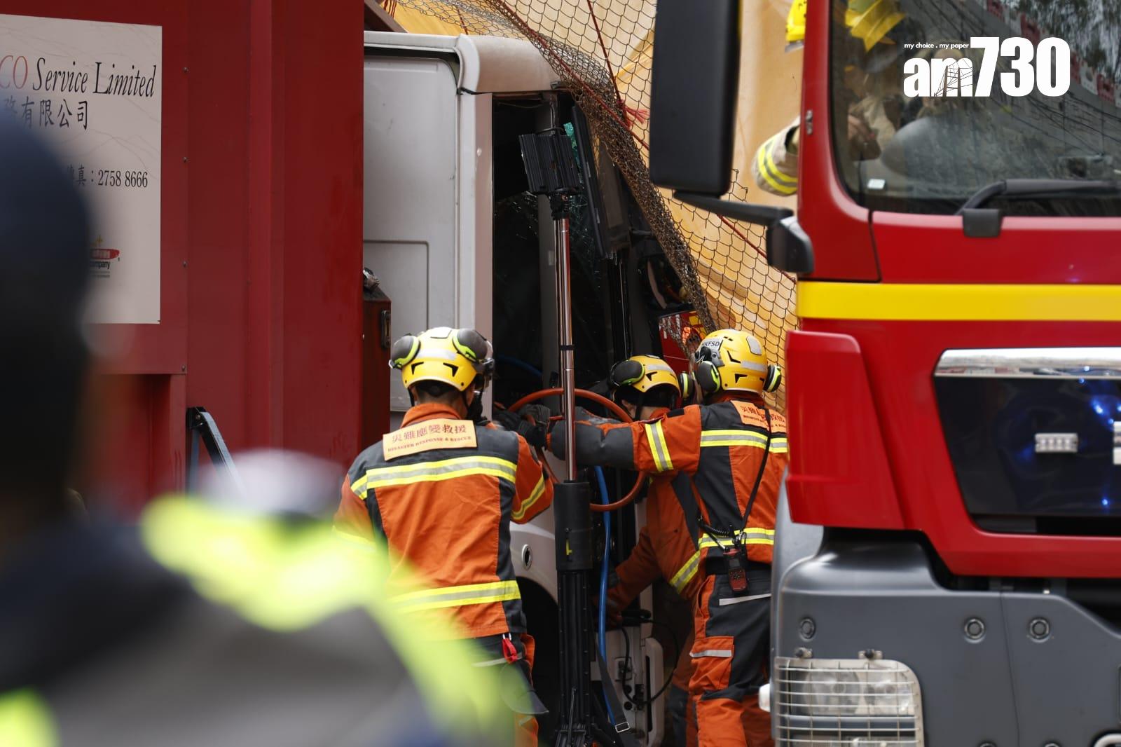 藍田康華苑對開連德道斜坡工地意外,垃圾車內一名乘客被夾車內,消防員正在場拯救。(林俊源攝)