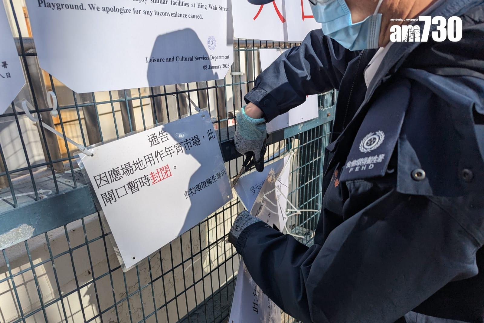 長沙灣農曆年宵市場已於下午3時許重開,食環署員工移除年宵封閉告示。(羅庸軒攝)