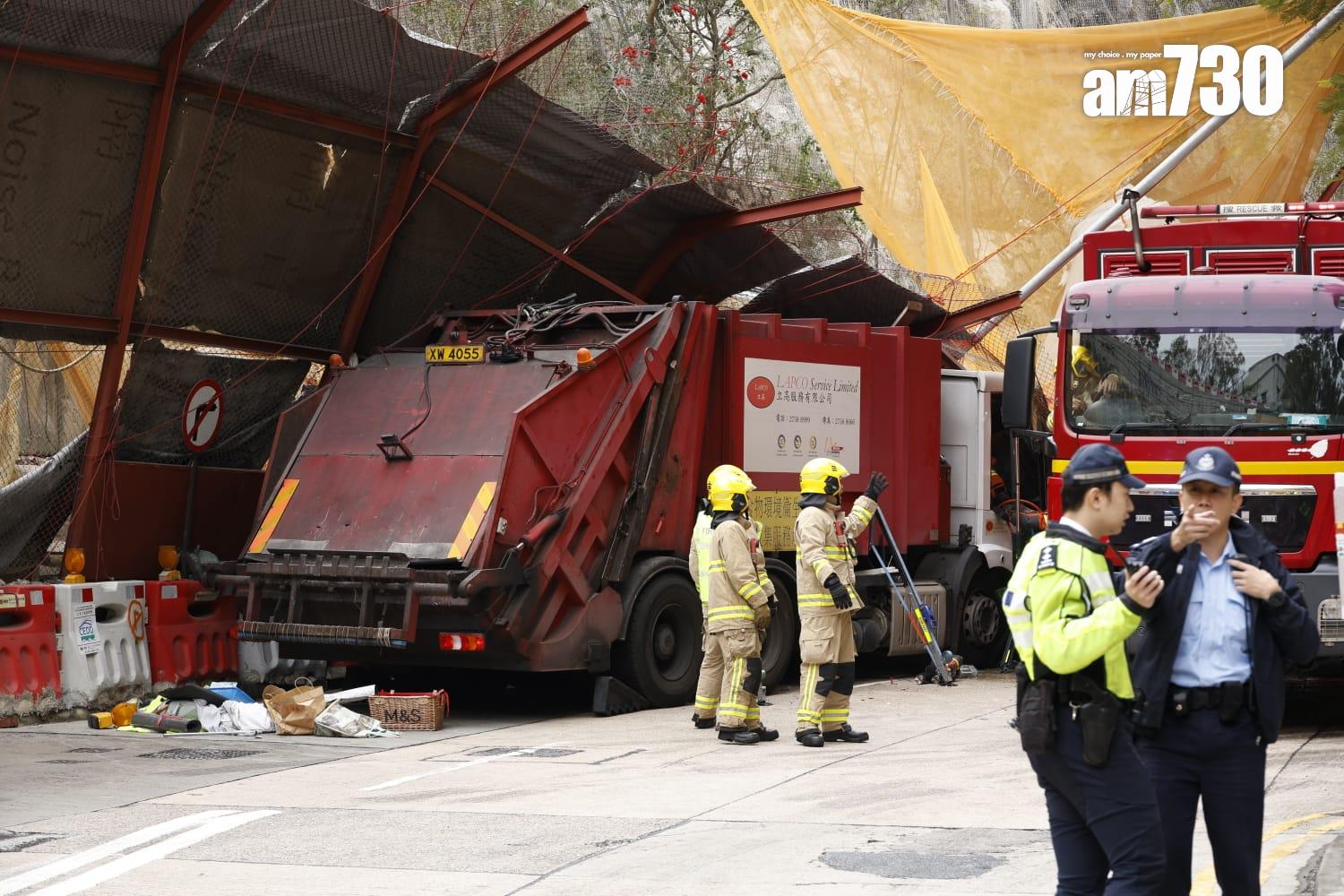 藍田康華苑對開連德道斜坡工地意外,垃圾車內一名乘客被夾車內,消防員正在場拯救。(林俊源攝)