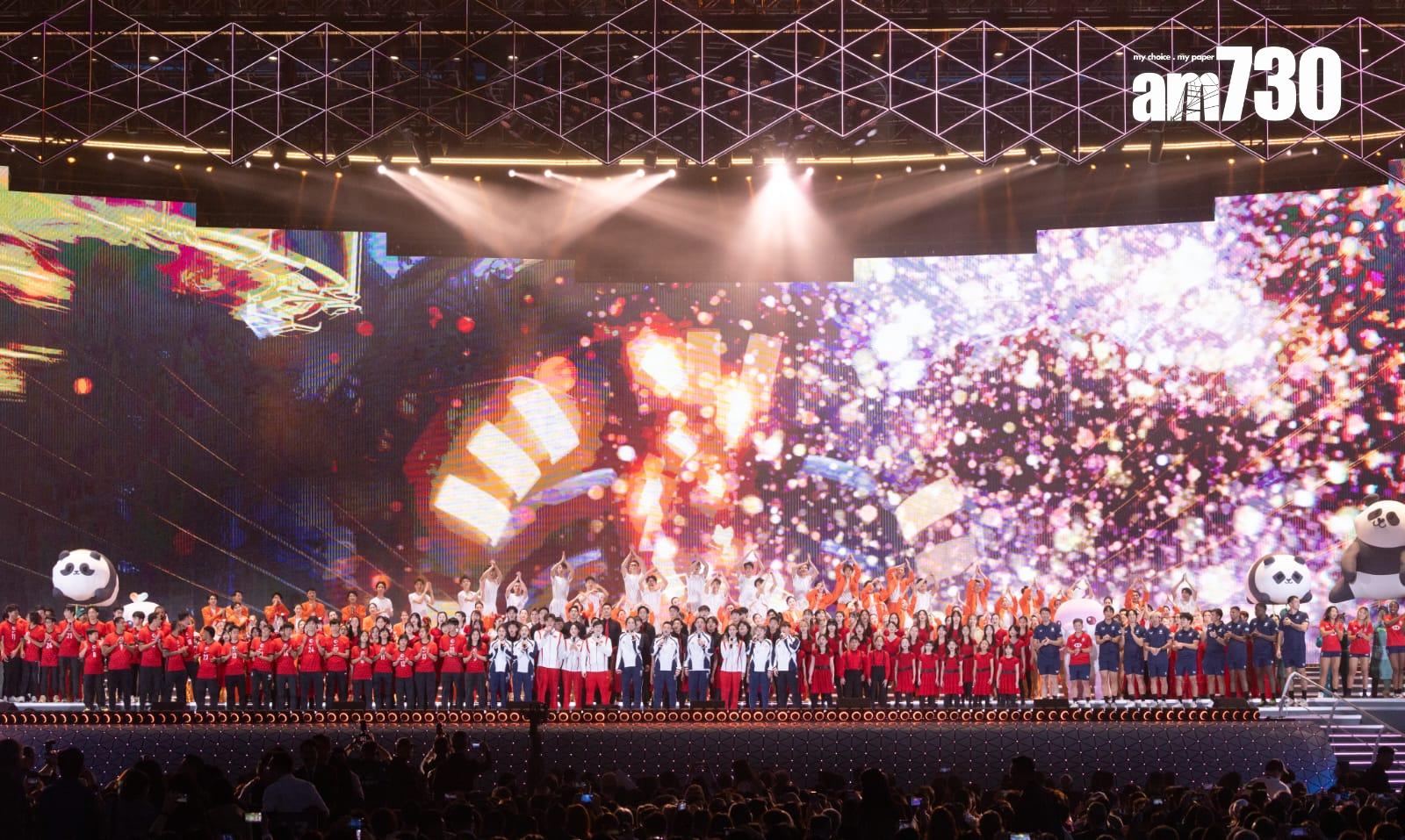 參與啟德體育園開幕禮的運動員及表演嘉賓在全運會吉祥物陪同下,在台上合唱歌曲「壯志驕陽」,結束典禮,並發放煙花。(蘇文傑攝)